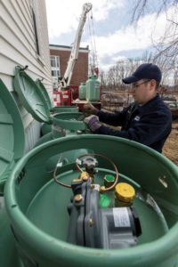 Travis Petrin, service technician with Eastern Propane, connects three new 120-gallon LP tanks to serve the home's new boiler. 