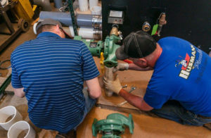 Technicians level a boiler pump.